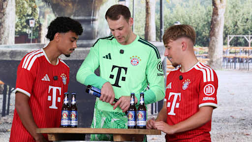 Manuel Neuer öffnet eine Bierflasche, Brown und Karl schauen zu