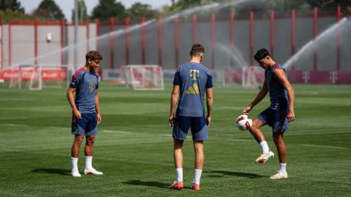 Tom Bischof, Aleksandar Pavlovic und Josip Stanisic halten den Ball hoch