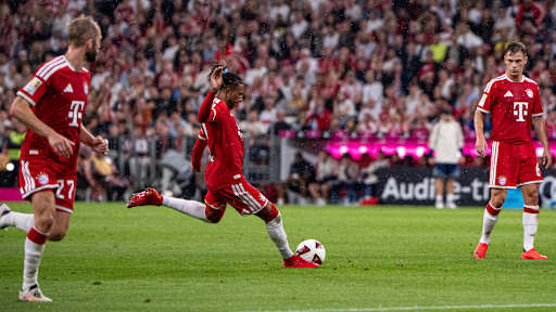 Michael Olise schießt einen direkten Freistoß im Bundesliga-Eröffnungsspiel des FC Bayern gegen den VfB Stuttgart