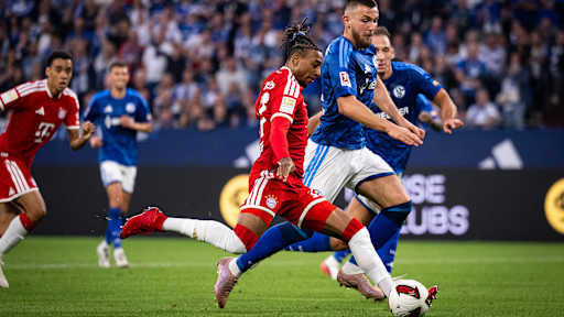 Michael Olise spielt den Ball im Fallen nach innen im Bundesliga-Spiel des FC Bayern beim FC Schalke 04