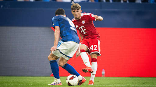 Lennart Karl spielt seinem Gegenspieler den Ball durch die Beine im Bundesliga-Spiel des FC Bayern beim FC Schalke 04