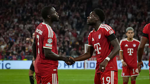 Dayot Upamecano und Alphonso Davies geben sich die Hand während des Heimspiels des FC Bayern in der Champions League gegen FK Bodø/Glimt
