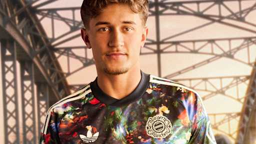 Tom Bischof  trägt das neue FC Bayern-Wiesn-Trikot 2026/27 mit farbenfrohem floralen Muster, im Hintergrund ist die Münchner Hackerbrücke zu sehen