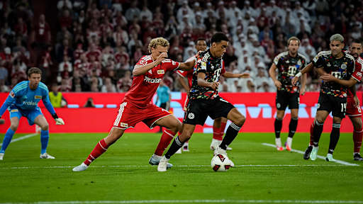 Jamal Musiala im Zweikampf mit Ball am Fuß während des Bundesligaspiels zwischen dem FC Bayern und Union Berlin