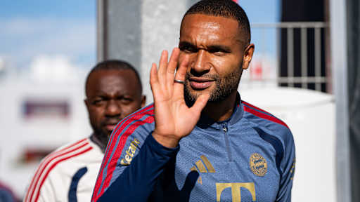 Jonathan Tah winkend auf dem Weg zum Platz vor dem Abschlusstraining des FC Bayern vor dem Bundesliga-Spiel gegen RB Leipzig.
