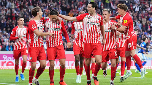 Freiburger Spieler um Derry Scherhant und Igor Matanovic jubeln nach einem Tor in der Bundesliga.