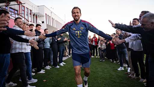 Harry Kane klatscht mit Mitarbeitern des FC Bayern auf dem Trainingsplatz ab