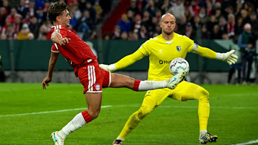 Tom Bischof versucht den Ball an Gäste-Keeper Reimann vorbeizuspitzeln im DFB-Pokalspiel des FC Bayern gegen den 1. FC Magdeburg