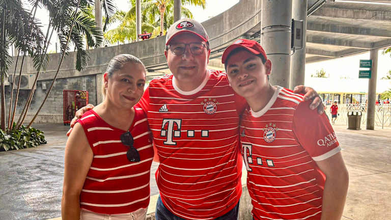 Mother, father and son stand together arm in arm