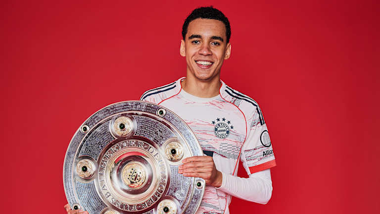 Jamal Musiala vom FC Bayern jubelt mit der Meisterschale.
