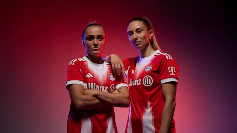 Georgia Stanway und Kathi Naschenweng posieren im neuen Home-Trikot der FC Bayern Frauen.