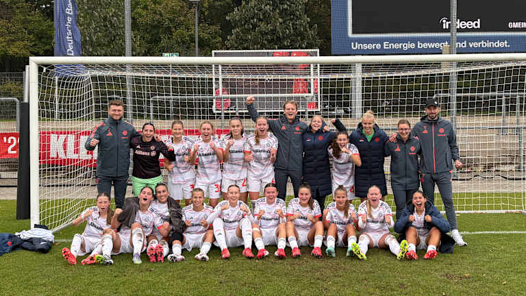 Teamfoto der FC Bayern Frauen II jubelnd vor dem Tor beim Auswärtssieg in Frankfurt