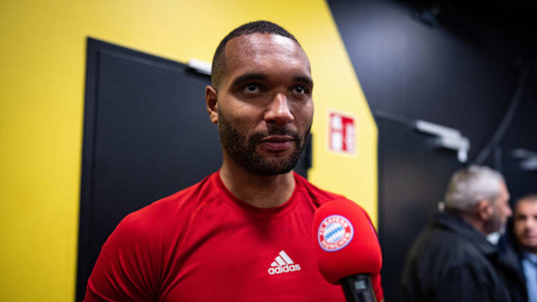 Jonathan Tah in red being interviewed after the Dortmund game