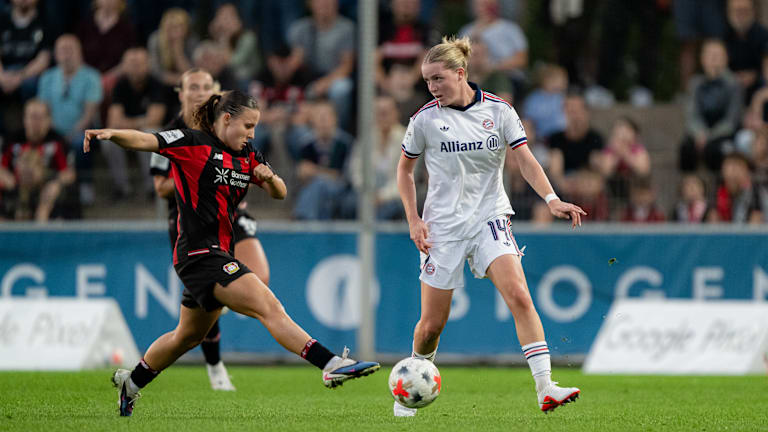 Alara mit dem Ball am Fuß, während eine Leverkusenerin auf sie zustürmt.