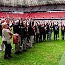 Fans des FC Bayern machen am Spielfeldrand der Allianz Arena eine Laola-Welle