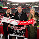 Der ehemalige FC Bayern-Präsident Karl Hopfner nimmt den Spendenscheck des Fanclubs Red Eagles Austria entgegen.