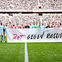Die Spieler halten ein Banner mit der Aufschrift "Rot gegen Rassismus" vor dem Heimspiel des FC Bayern in der Bundesliga gegen den 1. FC Union Berlin