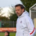 Holger Sritz in einer FC Bayern Trainingsjacke schaut nach links.