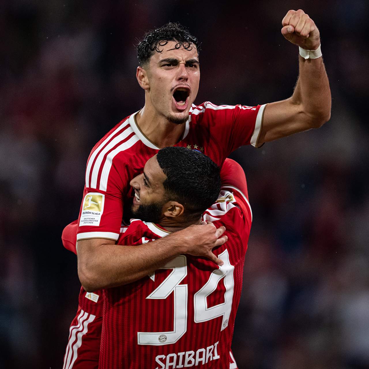 Aleks Pavlovic jubelt mit Vorlagengeber Ismael Saibari nach dem 4:1 im Bundesliga-Eröffnungsspiel des FC Bayern gegen den VfB Stuttgart