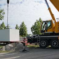 Trafostation für E-Ladepark an der Allianz Arena hängt an einem Kran