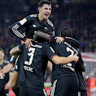 Aleksandar Pavlovic springt auf die Schultern seiner Teamkollegen nach dem 2:1 von Minjae Kim im Bundesliga-Spiel des FC Bayern beim 1. FC Köln