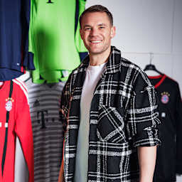 Manuel Neuer steht vor seinen Trikots