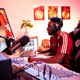 Alphonso Davies sitzt an einem Mischpult für Musik