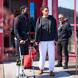 Alphonso Davies auf Krücken und Jamal Musiala schauen zu beim Training des FC Bayern