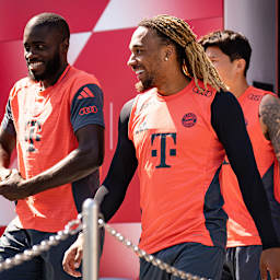 Dayot Upamecano und Sacha Boay lächelnd auf dem Weg zum Trainingsplatz des FC Bayern.
