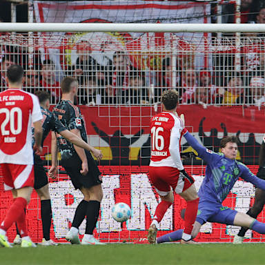 Jonas Urbig (Bayern München) scheitert mit seinem Schuss an Benedict Hollerbach (1.FC Union Berlin), der das erste Tor für sein Team erzielt.