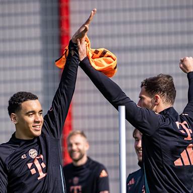 Jamal Musiala und Leon Goretzka klatschen sich im Training des FC Bayern ab