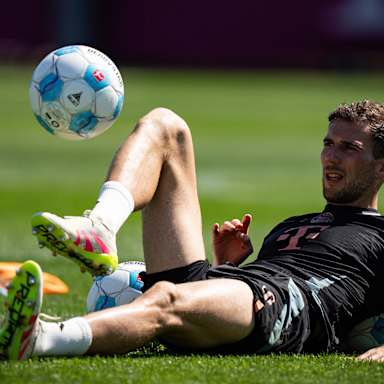 Leon Goretzka jongliert liegend einen Ball auf dem Rasen im Training des FC Bayern