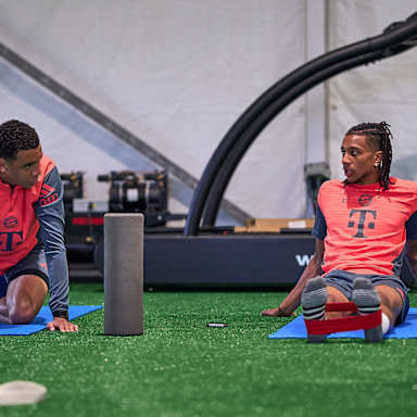 Jamal Musiala und Michael Olise beim Stretching im Training des FC Bayern in Orlando.