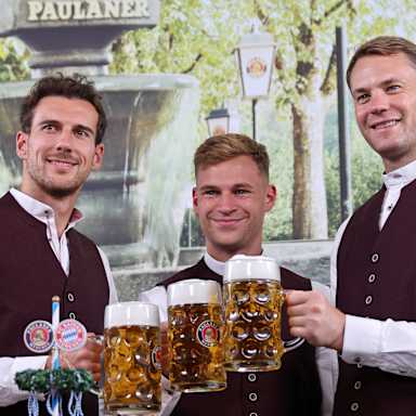 Leon Goretzka, Joshua Kimmich und Manuel Neuer stoßen mit Maßkrügen an