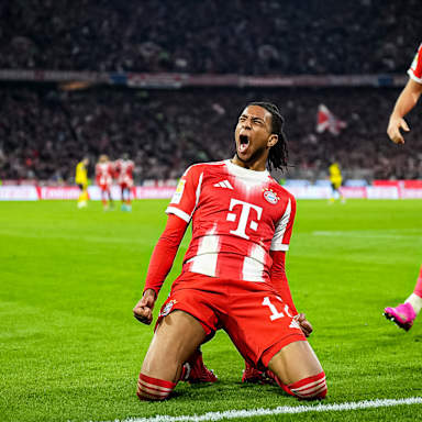 Michael Olise jubelt auf den Knien während des Bundesliga-Heimspiels des FC Bayern gegen Borussia Dortmund
