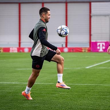 Raphael Guerreiro jongliert vor dem lachenden Harry Kane im Abschlusstraining des FC Bayern vor dem Spiel gegen Brügge