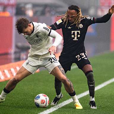 Sacha Boey führt einen Zweikampf im Bundesliga-Spiel des FC Bayern bei Borussia Mönchengladbach.