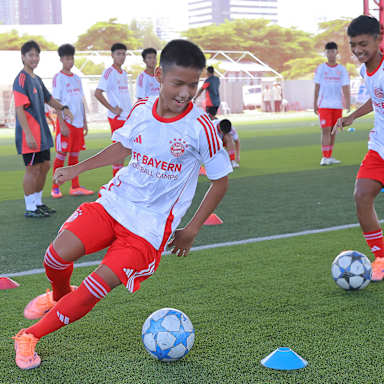 Ein junger Fußballspieler dribbelt um ein Hütchen beim Launch-Event mit CRC Sports als neuer Merchandising- und Vertriebspartner des FC Bayern in Thailand.