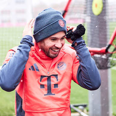 Raphael Guerreiro betritt den Platz lachend vor dem Abschlusstraining des FC Bayern vor dem Bundesliga-Spiel gegen Freiburg