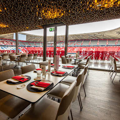 Business Club - niedrige Tisch vor Glasfront, mit Blick ins Stadioninnere