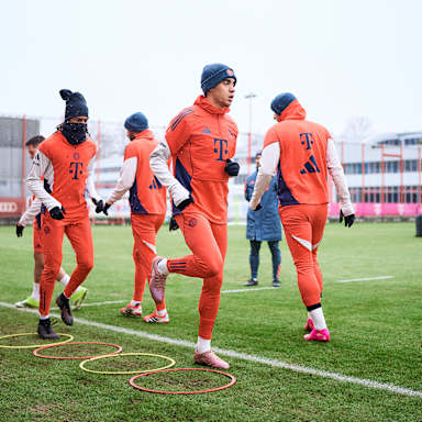 Jamal Musiala und Michael Olise laufen sich  im Training des FC Bayern warm