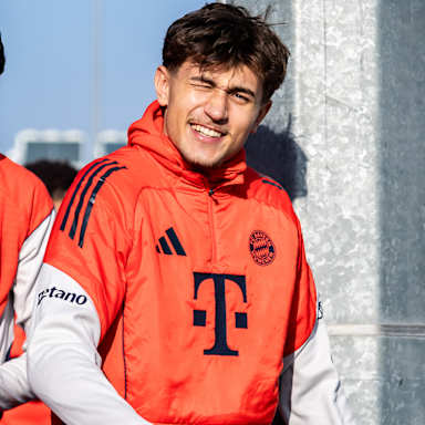 Tom Bischof betritt lächelnd den Platz im Training des FC Bayern vor dem Bundesliga-Spiel gegen den FC Augsburg