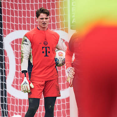 Jonas Urbig hält einen Ball im Training des FC Bayern