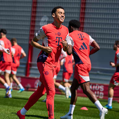Jamal Musiala läuft lächelnd vor Michael Olise im Abschlusstraining des FC Bayern vor dem Bundesliga-Spiel in Mainz