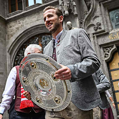 FC Bayerns Toptorjäger Harry Kane mit der Meisterschale am Münchner Marienplatz