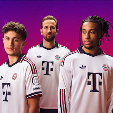 Tom Bischof, Michael Olise und Harry Kane tragen das neue FC Bayern Auswärtstrikot 2026/27 im Retro-Look in schlichtem Weiß mit Polo-Kragen und rot-marineblauen Details