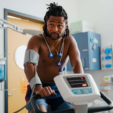 Serge Gnabry sitzt verkabelt auf einem Fahrradergometer bei der sportmedizinischen Untersuchung