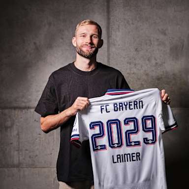 Konrad Laimer bei seiner Vertragsverlängerung mit dem weißen Trikot in der Hand.