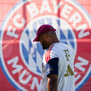 Trainer Vincent Kompany vor einem großen Bayern-Logo im Training des FC Bayern