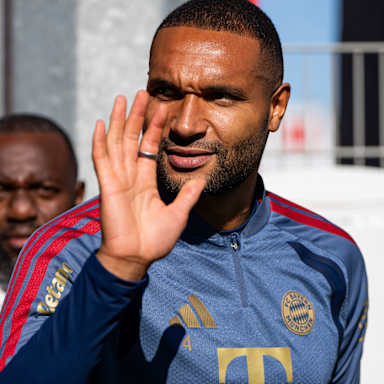 Jonathan Tah winkend auf dem Weg zum Platz vor dem Abschlusstraining des FC Bayern vor dem Bundesliga-Spiel gegen RB Leipzig.
